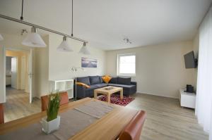 ein Wohnzimmer mit einem Sofa und einem Tisch in der Unterkunft Appartements Am Kurpark in Bad Windsheim