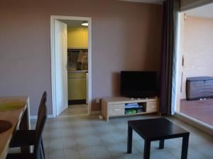 een woonkamer met een tafel en een televisie bij Appartement Cavalaire-sur-Mer, 2 pièces, 4 personnes - FR-1-226B-27 in Cavalaire-sur-Mer