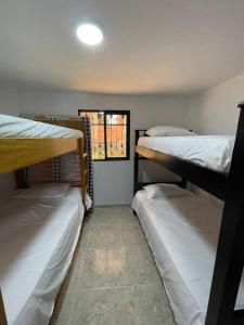 a room with three bunk beds and a window at Linda casa con espectacular vista embalse y piedra in Guatapé