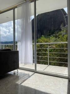 a room with a large window with a view at Linda casa con espectacular vista embalse y piedra in Guatapé