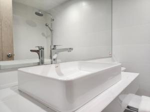 uma casa de banho branca com um lavatório e um espelho em Arsh Boutique Hotel em Chiang Mai