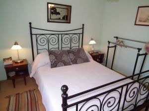1 cama en un dormitorio con 2 mesas y 2 lámparas en West Terrace House - Ocean View, en Lourinhã