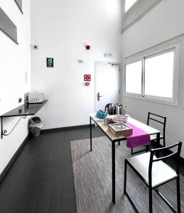 Habitación con mesa y sillas. en Hostal Apolo, en Barcelona