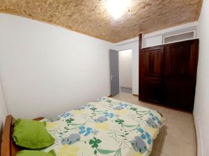 Schlafzimmer mit einem Bett und einer Holztür in der Unterkunft La Casa Emy in Saint-Leu