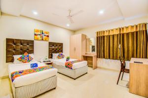 a hotel room with two beds and a desk at Fabhotel Pearl City - Nr Jubilee Enclave, Hitech City in Hyderabad +16 photos