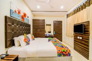 - une chambre avec un grand lit et une télévision dans l'établissement FabHotel Pearl City HiTech City, à Hyderabad
