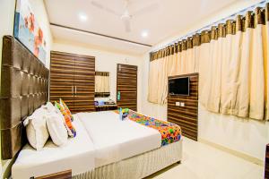 a bedroom with a large bed and a television at FabHotel Pearl City HiTech City in Hyderabad