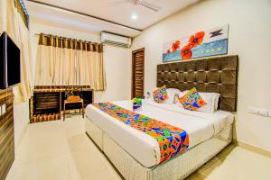a bedroom with a large bed and a fireplace at FabHotel Pearl City HiTech City in Hyderabad