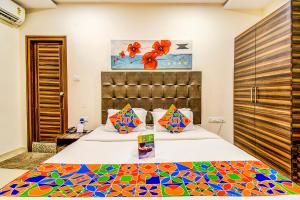 - une chambre avec 2 lits et un couvre-lit coloré dans l'établissement FabHotel Pearl City HiTech City, à Hyderabad