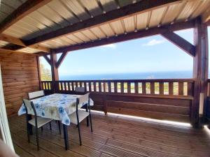 einen Tisch und Stühle auf einem Balkon mit Meerblick in der Unterkunft La Casa Emy in Saint-Leu