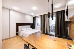 een slaapkamer met een bed en een eettafel bij 7th Floor Atelier Praga Studio in Warschau