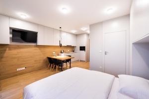 een slaapkamer met een bed en een tafel en een keuken bij 7th Floor Atelier Praga Studio in Warschau