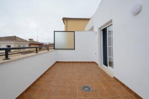 balcón con paredes blancas y suelo de baldosa. en DUPLEX VISTANEVADA MARACENA, en Maracena