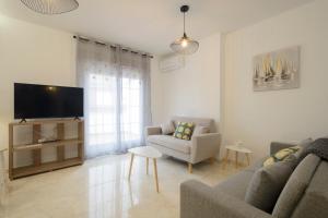 a living room with a couch and a tv at DUPLEX VISTANEVADA MARACENA in Maracena