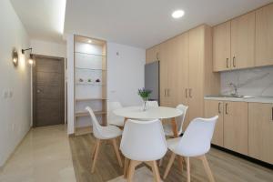 uma cozinha com uma mesa branca e cadeiras brancas em DUPLEX VISTANEVADA MARACENA em Maracena