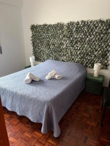 ein Schlafzimmer mit einem Bett mit zwei Handtüchern darauf in der Unterkunft CASA JUDITE in Faro