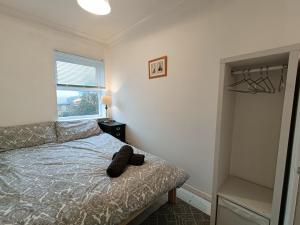 un dormitorio con una cama con un animal de peluche en 2 Bed Functional House Close to Manor Park Train Station en Londres