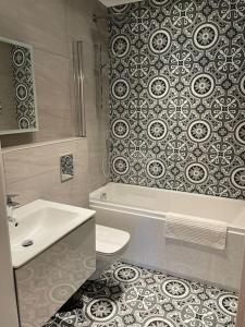 a bathroom with a toilet and a tub and a sink at Boutique Luxury Apartment, High St, Henley-in-Arden in Henley in Arden