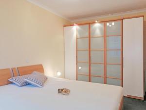 - une chambre avec un grand lit blanc et un placard dans l'établissement Residenz Ostseestrand, à Kühlungsborn