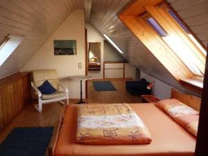 um quarto no sótão com uma cama e uma cadeira em Freiburg Citywohnung em Friburgo em Brisgóvia