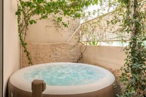 a jacuzzi tub in a garden with plants at Amazing House with Jacuzzi and Huge PVT Garden in Athens
