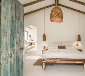 a bedroom with a bed and a hanging lamp at Vila Oyá - praia de algodões in Marau