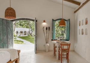 ein Schlafzimmer mit einem Tisch, einem Bett und einem Fenster in der Unterkunft Vila Oyá - praia de algodões in Marau