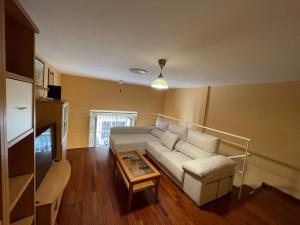 a living room with a white couch and a coffee table at DreamsApt Plaza Nueva II in Seville