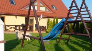 a playground with a blue slide in a yard at Rowy, Słoneczne plaże in Rowy