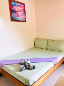 Una habitación con una cama con un osito de peluche. en Lolo Bob's Bed And Breakfast en El Nido
