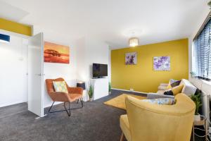 sala de estar con paredes amarillas, sofá y sillas en Brambles House West Drayton 3 Bedroom House with parking By MDPS, en West Drayton
