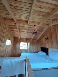 1 dormitorio con 2 camas en una cabaña de madera en olive garden bungalow, en Fethiye