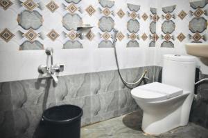 a bathroom with a toilet and a sink at Hotel Unique Stays in Rājampet +36 photos