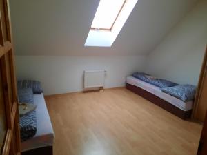 a small room with two beds and a skylight at Apartmán Chiarita in Nemšová