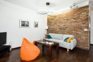 uma sala de estar com um sofá e uma parede de tijolos em Poznań City Centre Osiedle Galileo Apartment by Renters em Poznań