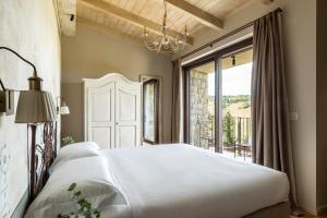 a bedroom with a large bed and a large window at Country House Oliveto sul Lago in San Nicolò