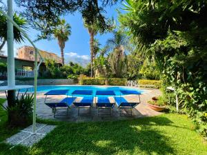 un patio con mesa y sillas junto a una piscina en Villa Talìa, en Carini