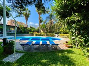 a patio with a table and chairs next to a pool at Villa Talìa in Carini