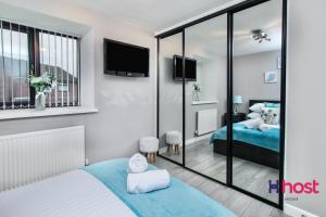 - une chambre avec un lit et un miroir dans l'établissement Host Liverpool - Cosy Family Home, Parking, Liverpool, à West Derby