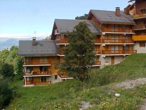 a large apartment building on a hill with a tree at Appartement Méribel, 3 pièces, 5 personnes - FR-1-180-122 in Méribel