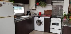 cocina con lavadora y lavadora en Departamento céntrico en Villa Carlos Paz