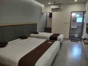 a hotel room with two beds and a bathroom at Apollostay in Chennai