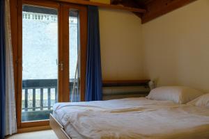 a bedroom with a bed and a large window at Seewohnung 1 in Spiez