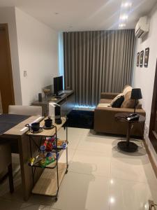 ein Wohnzimmer mit einem Sofa und einem Tisch in der Unterkunft Flat moderno e sofisticado in Rio de Janeiro