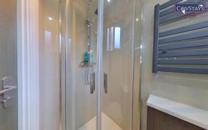 La salle de bains est pourvue d'une douche avec une porte en verre. dans l'établissement New House - Magnificent Studios in Coventry City Centre, free parking, by COVSTAYS, à Coventry