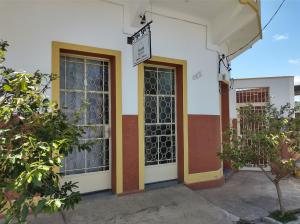 un bâtiment avec deux portes et un panneau sur celui-ci dans l'établissement Hostel Dom Bosco, à São João del Rei