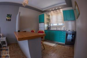 Iráklia的住宿－Atrium Vinea Brintziki Winery，厨房配有绿色橱柜和木制台面