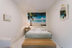 ein Schlafzimmer mit einem Bett und einem Gemälde an der Wand in der Unterkunft Best Houses 71 - Casa das Ondas in Peniche