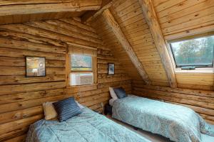 - une chambre avec 2 lits dans une cabane en rondins dans l'établissement Hartland Cabin, à Hartland