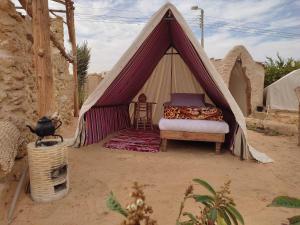 a bed in a tent in the desert at Grand Siwa in Siwa